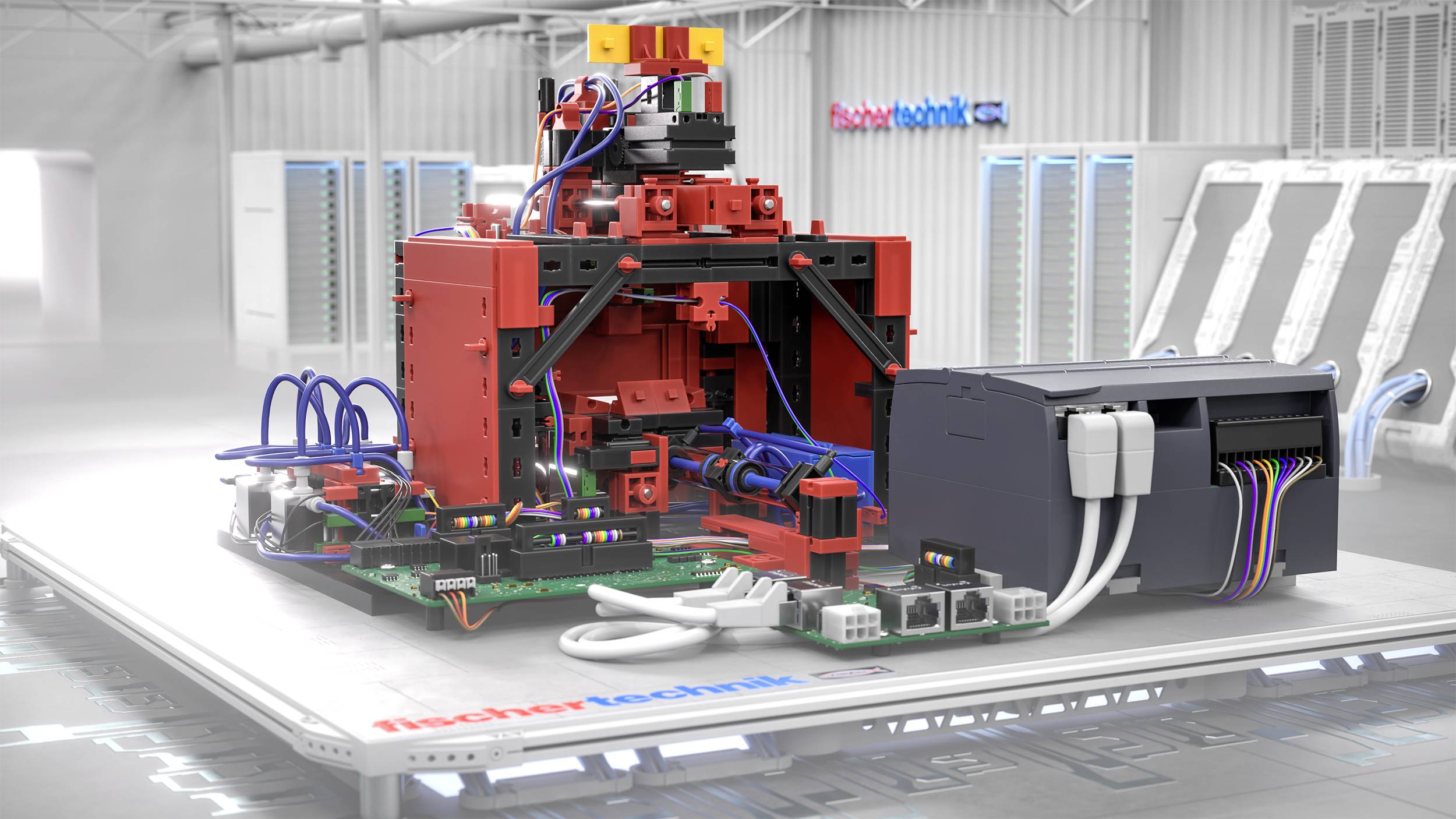 Červený a černý robotický model stojící na bílé platformě s kabely a elektronickými komponenty. V pozadí jsou skříně a nápis 'fischertechnik'.