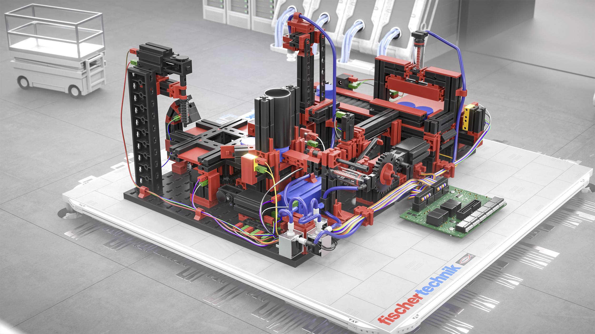 Komplexní mechanický model z dílů Fischertechnik umístěný na základní desce ukazuje různé červené a černé struktury a propojení kabelů.