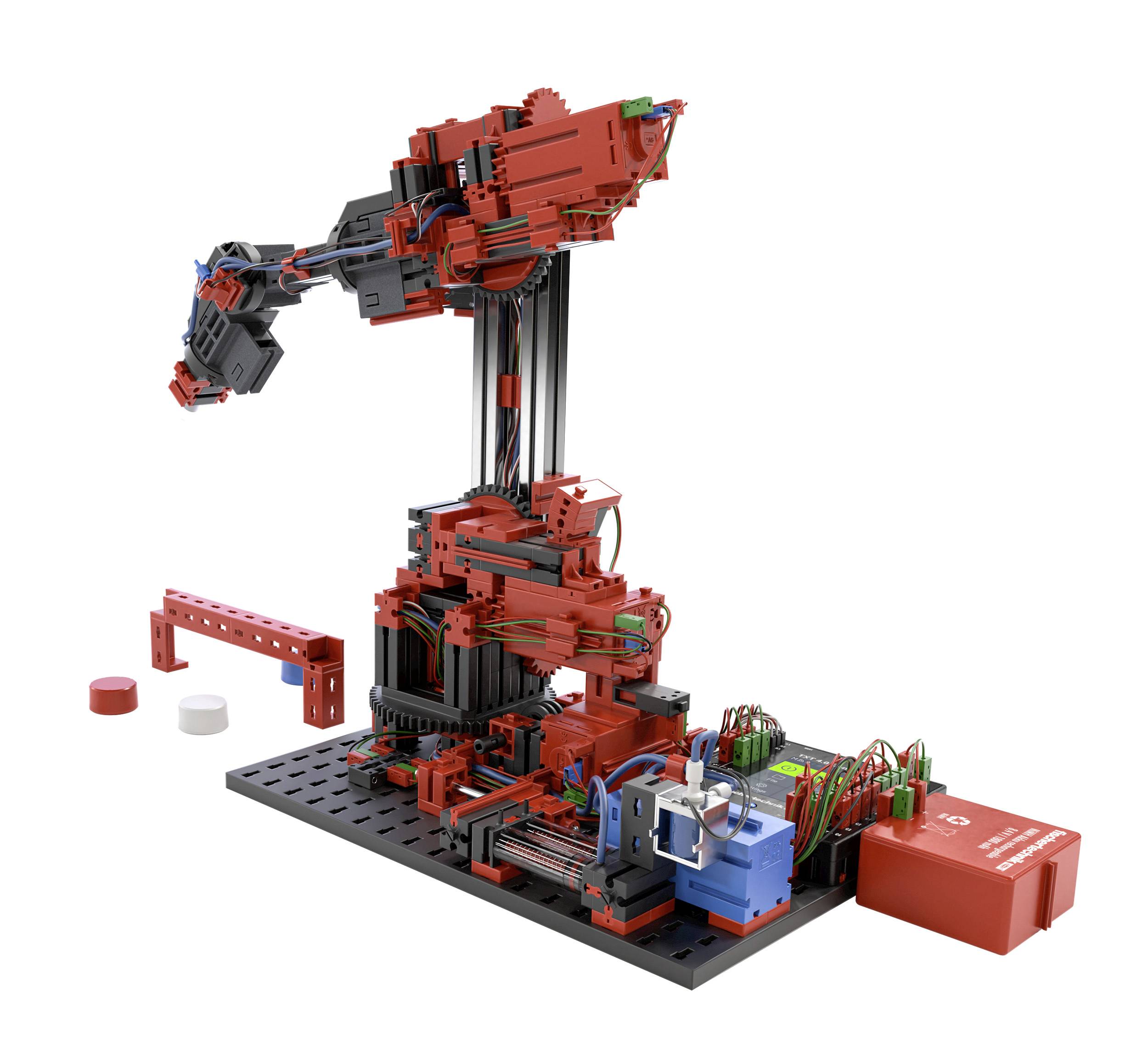 Červený a černý mechanický robotický rameno na černé základně, obklopen technickým příslušenstvím a kabely.