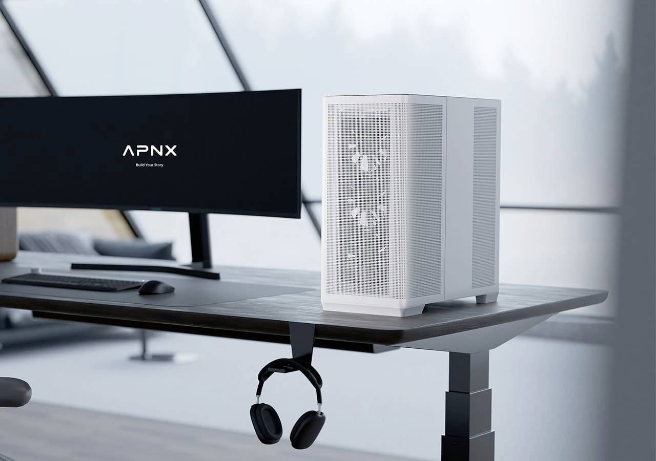 Elegantní, moderní sestava počítačového stolu s bílou PC věží, zakřiveným monitorem zobrazujícím 'APNX', klávesnicí a sluchátky zavěšenými pod monitorem.