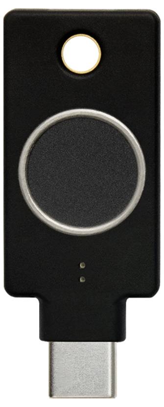 Černý USB bezpečnostní klíč s kruhovým dotykovým ovladačem a USB-C konektorem dole, určený pro dvoufaktorovou autentizaci.