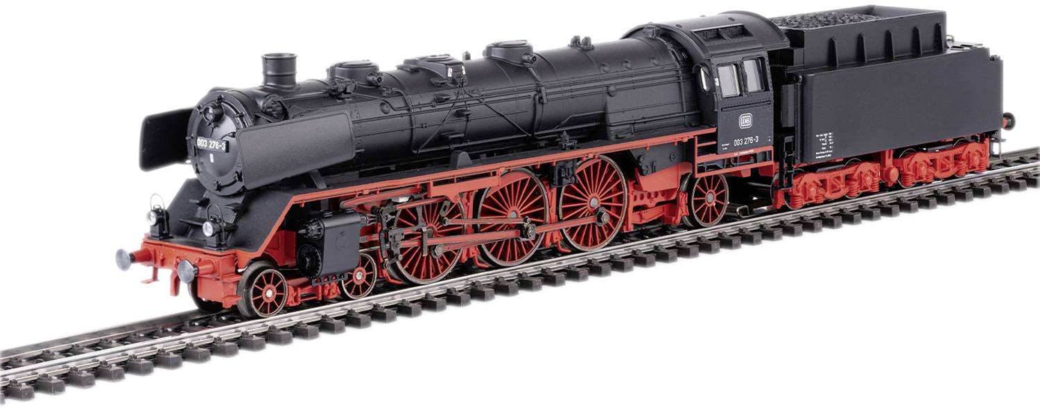 Černý model parní lokomotivy s červeným podvozkem jede po kolejích. Lokomotiva má řadu detailů a nápisů.
