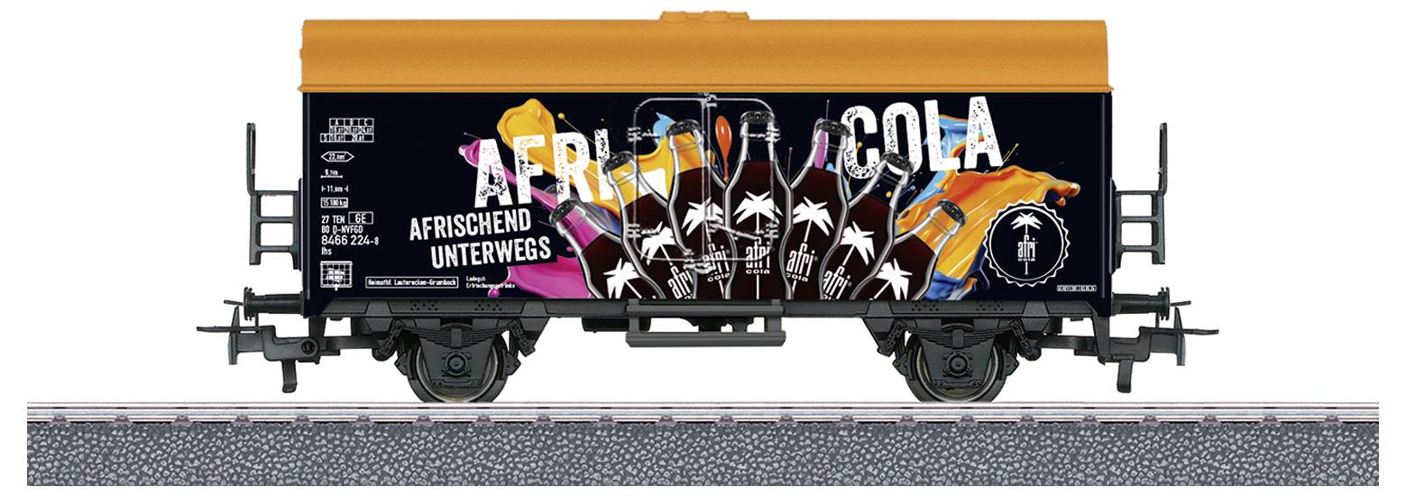 Nákladní vůz s oranžovo-černým designem, ozdobený barevnými lahvemi a textem 'Afrika-Cola - Osvěžení na cestách'.