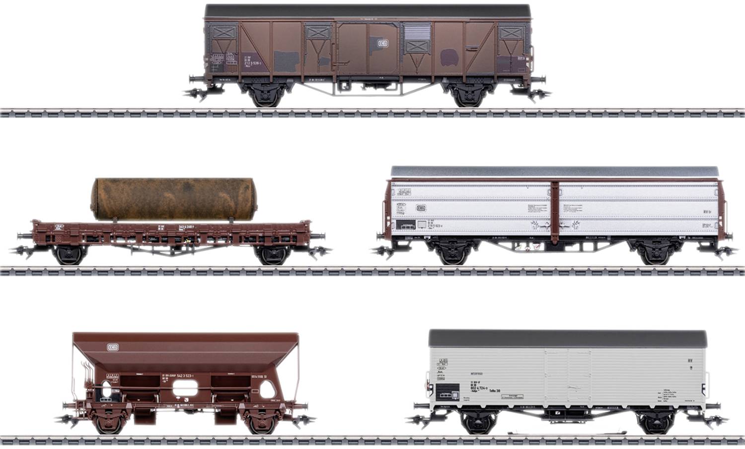 Pět různých nákladních vagónů na kolejích: uzavřený, otevřený s nákladem, krytý vůz pro sypký materiál. Scéna modelové železnice.