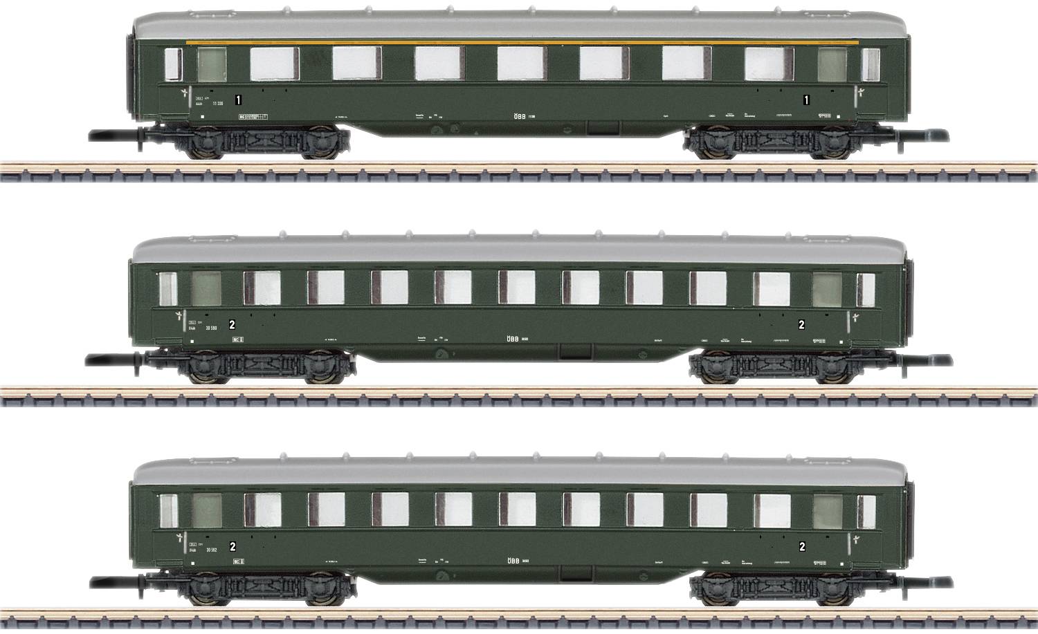 Tři zelené osobní vagóny modelové železnice umístěné jeden nad druhým na kolejích. Každý vagon má okna a bílou linii střechy.