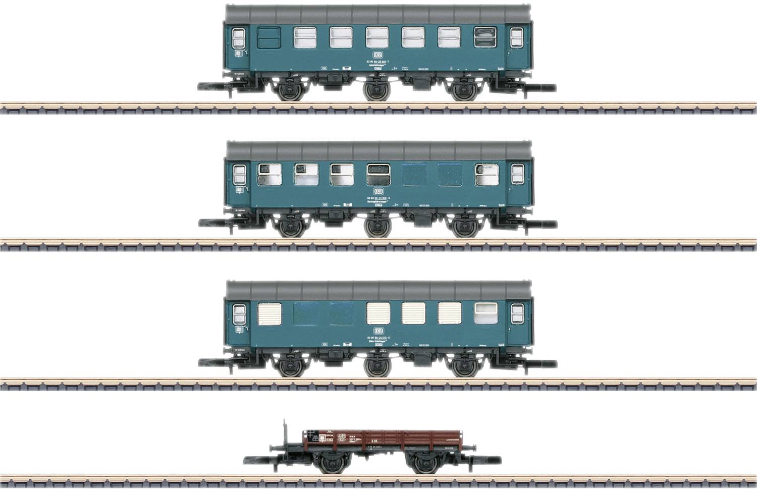 Čtyři modelové železniční vozy na kolejích: tři zelené osobní vagóny a jeden hnědý nákladní vůz v řadě.