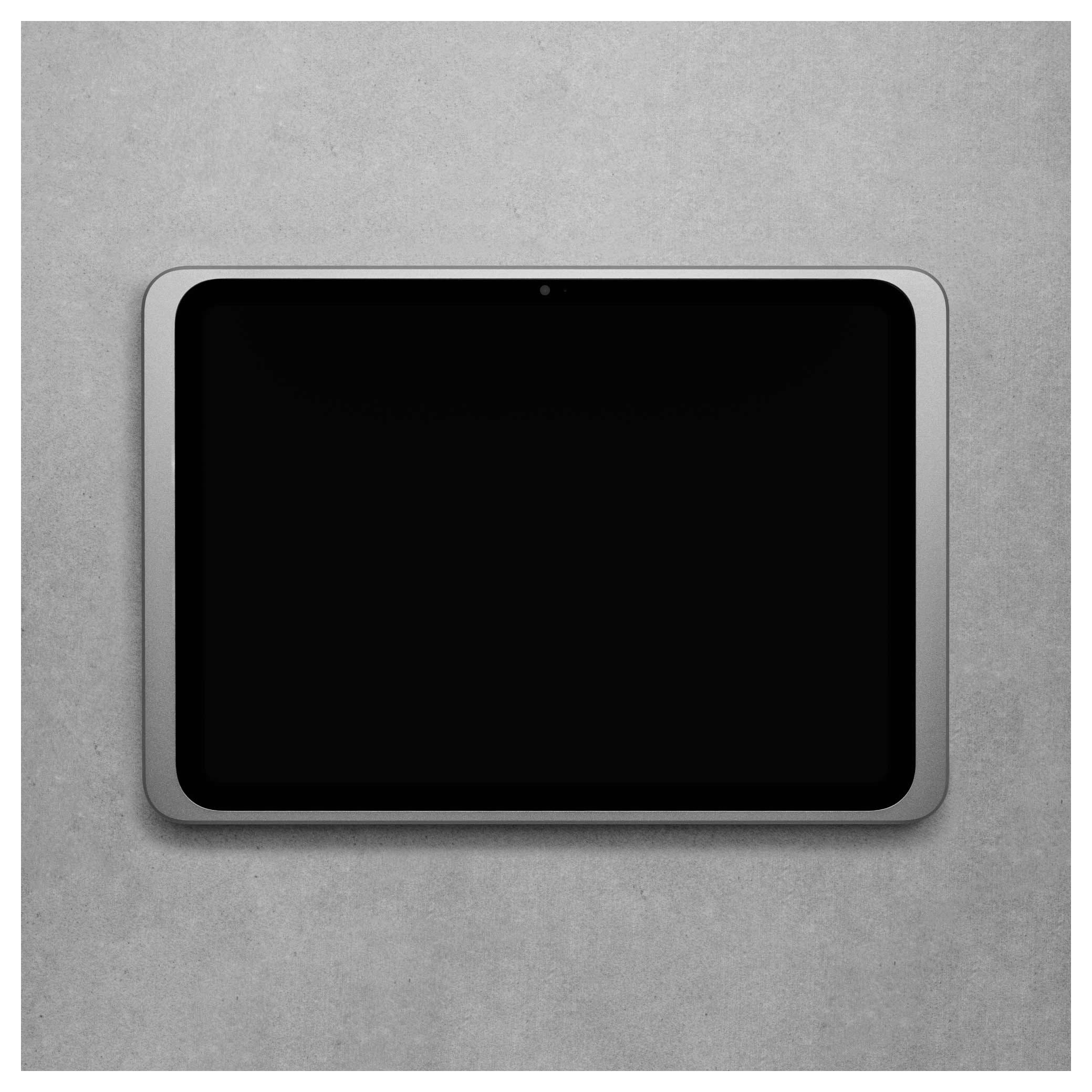 Tablet s černou obrazovkou, ležící na šedém betonovém povrchu.