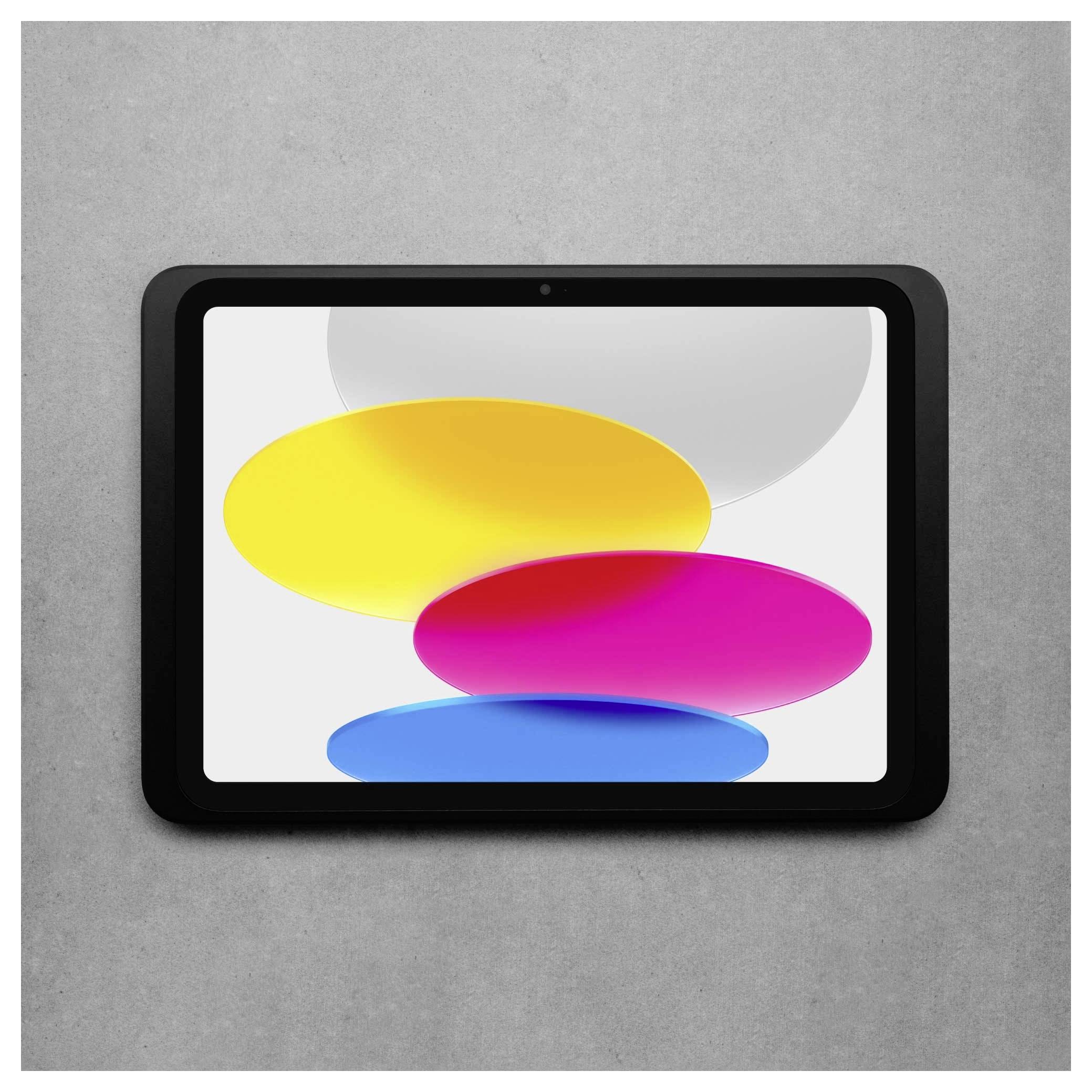 Tablet s černým rámečkem zobrazuje barevné oválné tvary na bílém pozadí. Pozadí tvoří šedý povrchový vzor.