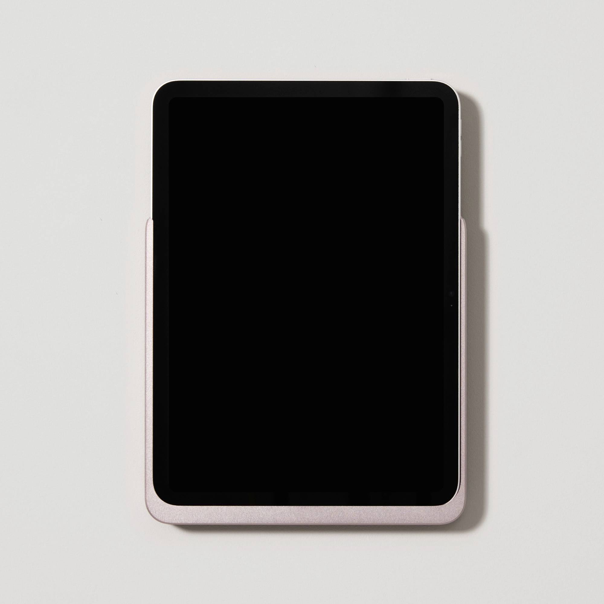 Tablet leží na bílém podkladu, obrazovka je vypnutá.