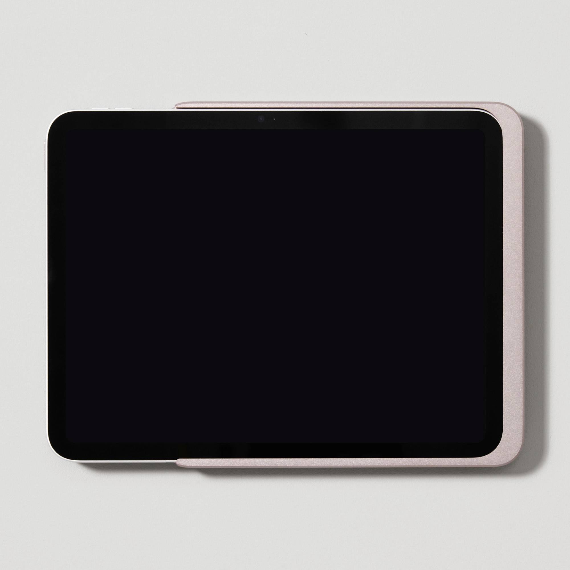 Černý tablet leží na bílém pozadí.