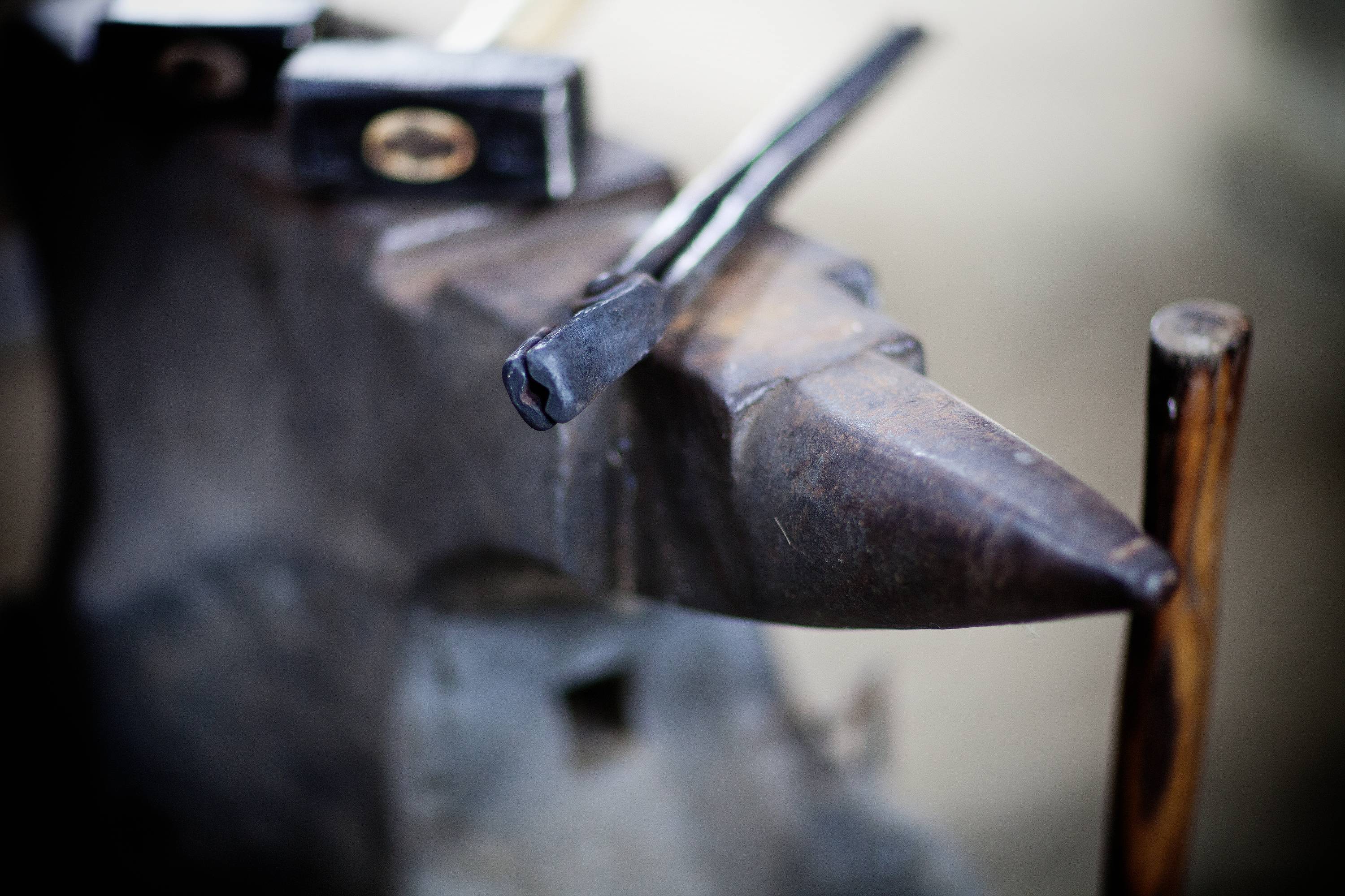 Kovadlina s černým kladivem v kovárně, v pozadí viditelné další nástroje.