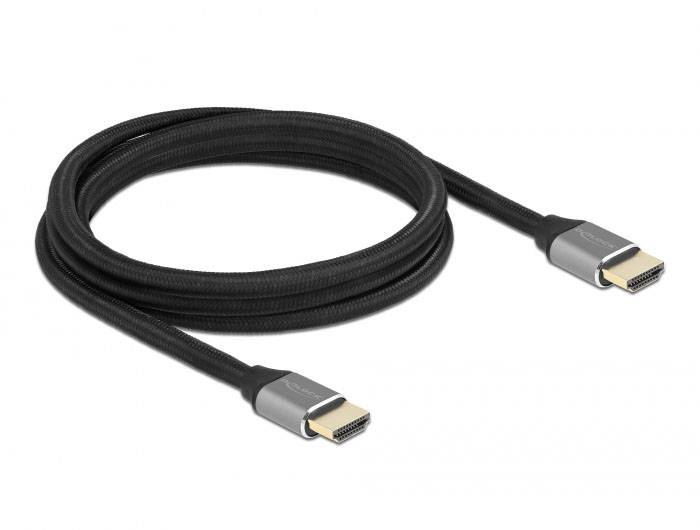 HDMI kabel se stříbrnými konektory a černým opletem, smotaný do otevřené smyčky na bílém pozadí.