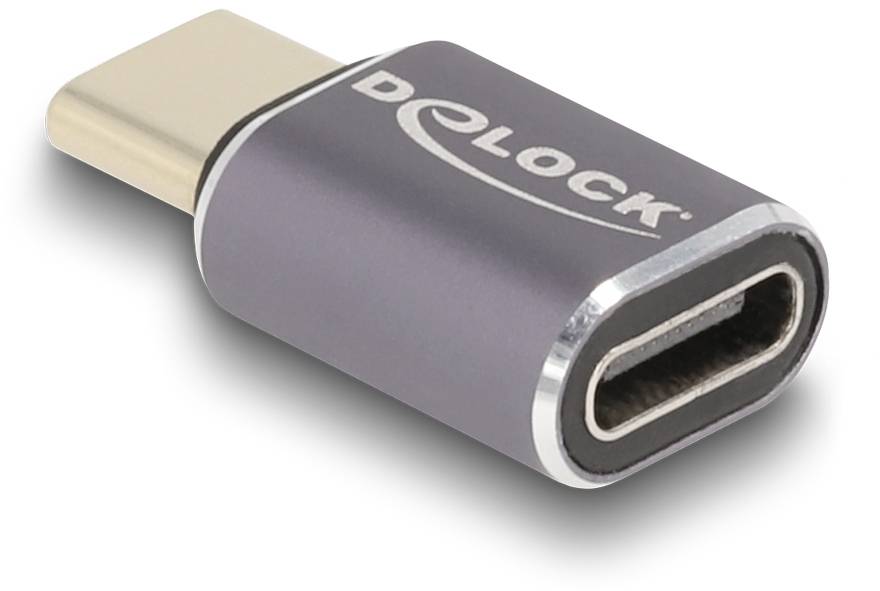 USB-C adaptér od Delocku, kovový, ukazuje stranu konektoru. Slouží k propojení zařízení s USB-C portem.