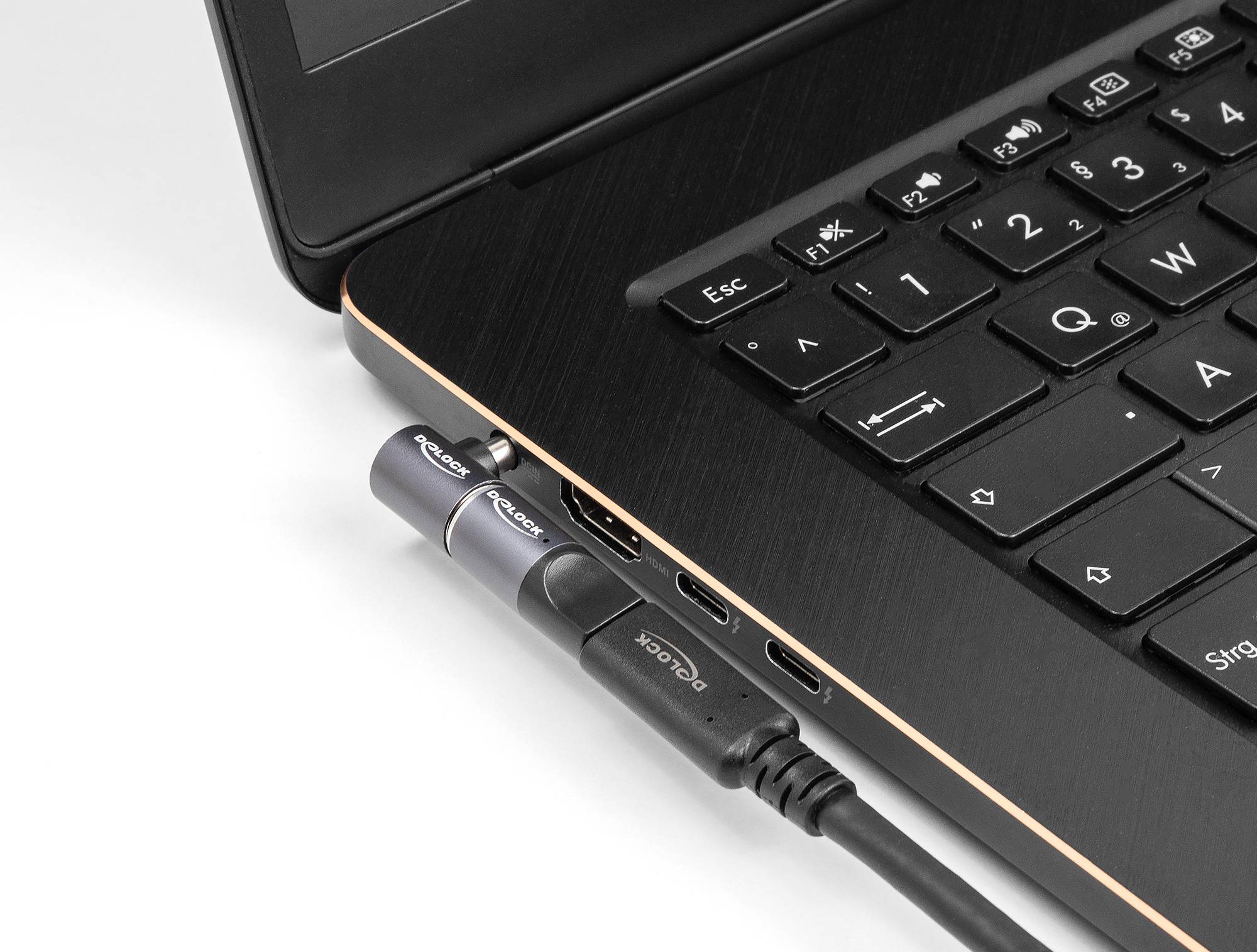 Detailní záběr notebooku s HDMI kabelem a USB-C portem umístěným na boku zařízení.