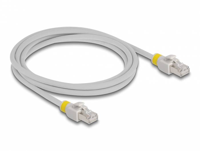 Šedý síťový kabel se dvěma konektory RJ45 a žlutými značkami na obou koncích je svinut na bílém povrchu.