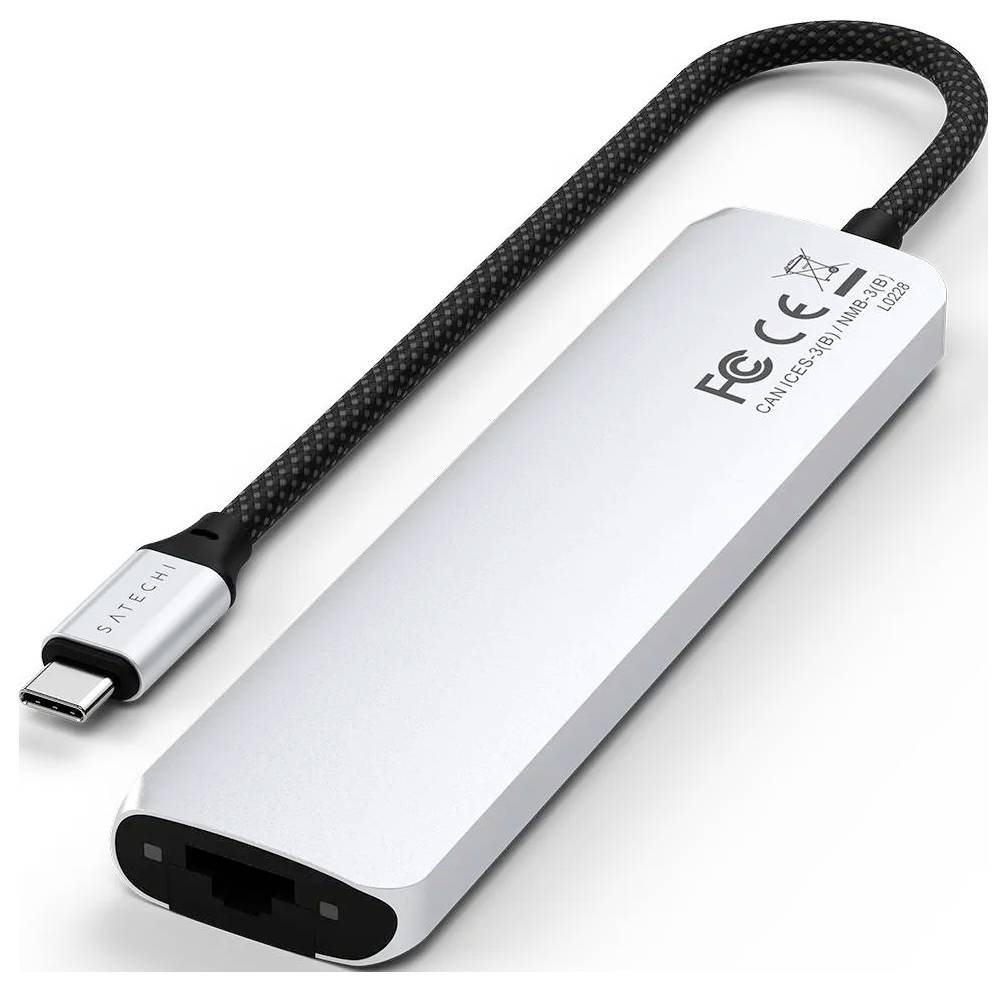 Stříbrný USB-C adaptér od Satechi s vestavěným černým kabelem. Disponuje ethernetovým portem a je označen CE a FCC symboly.
