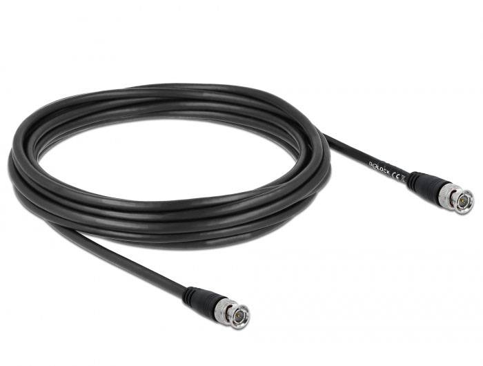 Černý koaxiální kabel se dvěma konektory na koncích, navinutý na povrchu.