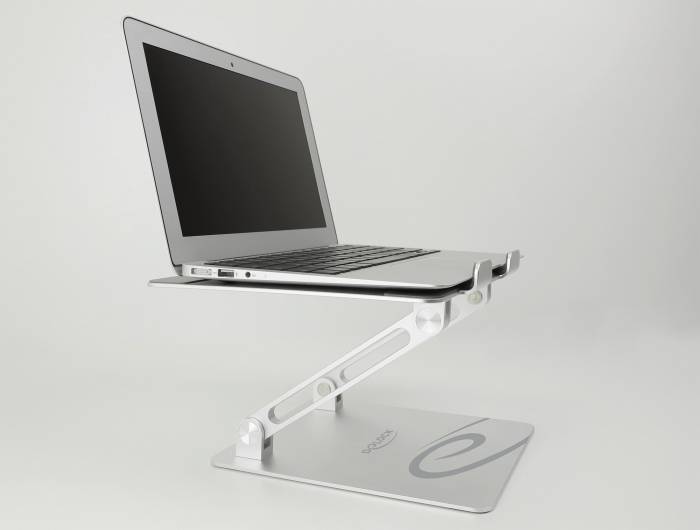 Notebook leží na nastavitelném stříbrném stojanu, který zvedá obrazovku do úrovně očí.