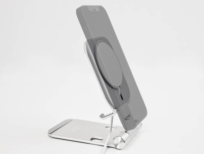 Smartphone stojí na stříbrném, nastavitelném stojanu s integrovaným nabíjecím kabelem. Stojan podporuje bezdrátové nabíjení.