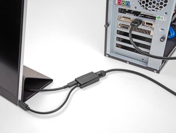 Počítačový monitor je připojen k desktopovému počítači. Obrázek ukazuje zadní stranu počítačové skříně s připojenými kabely.