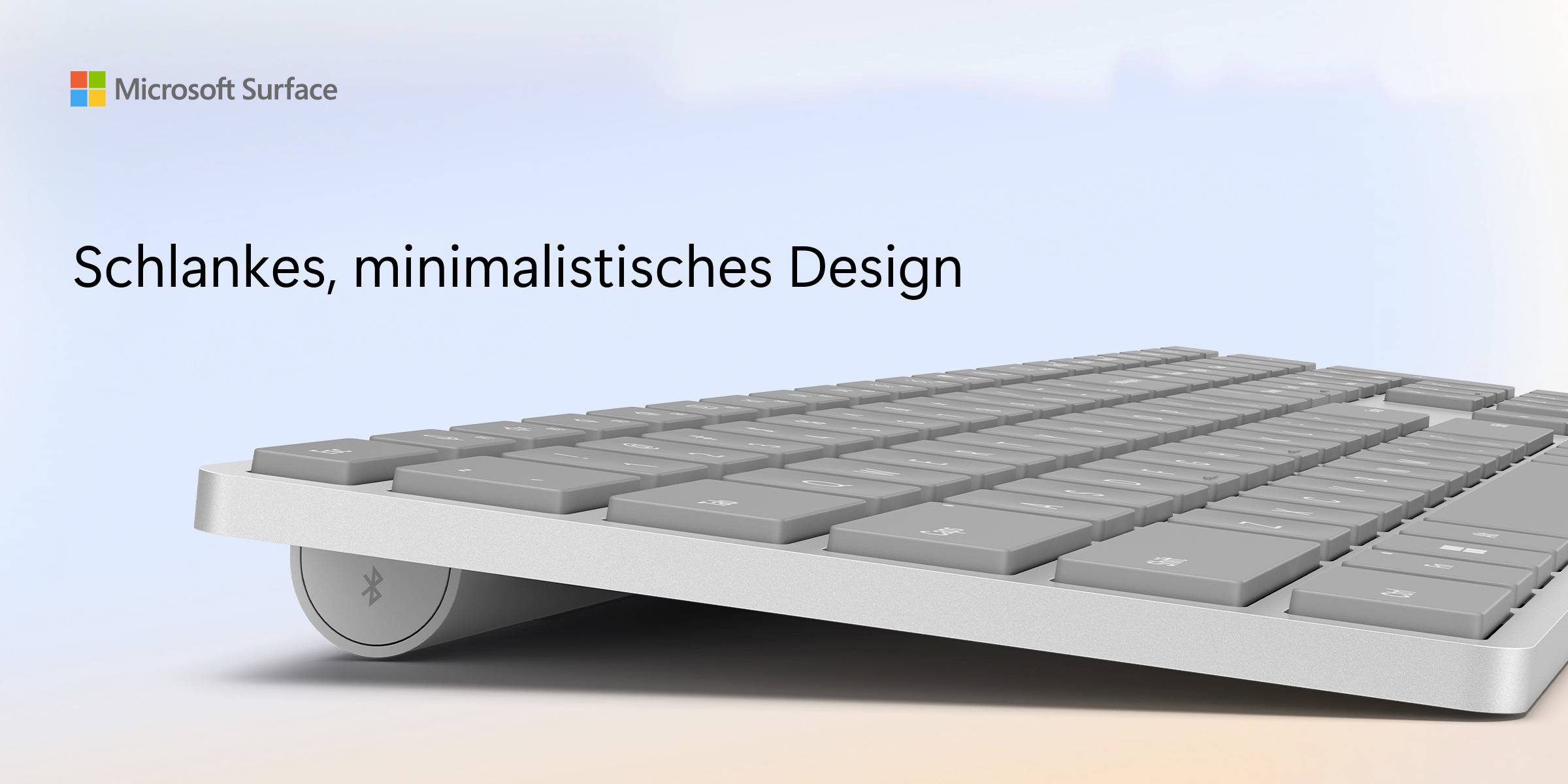 Klávesnice Microsoft Surface z bočního pohledu s elegantním, minimalistickým designem na modrém pozadí.