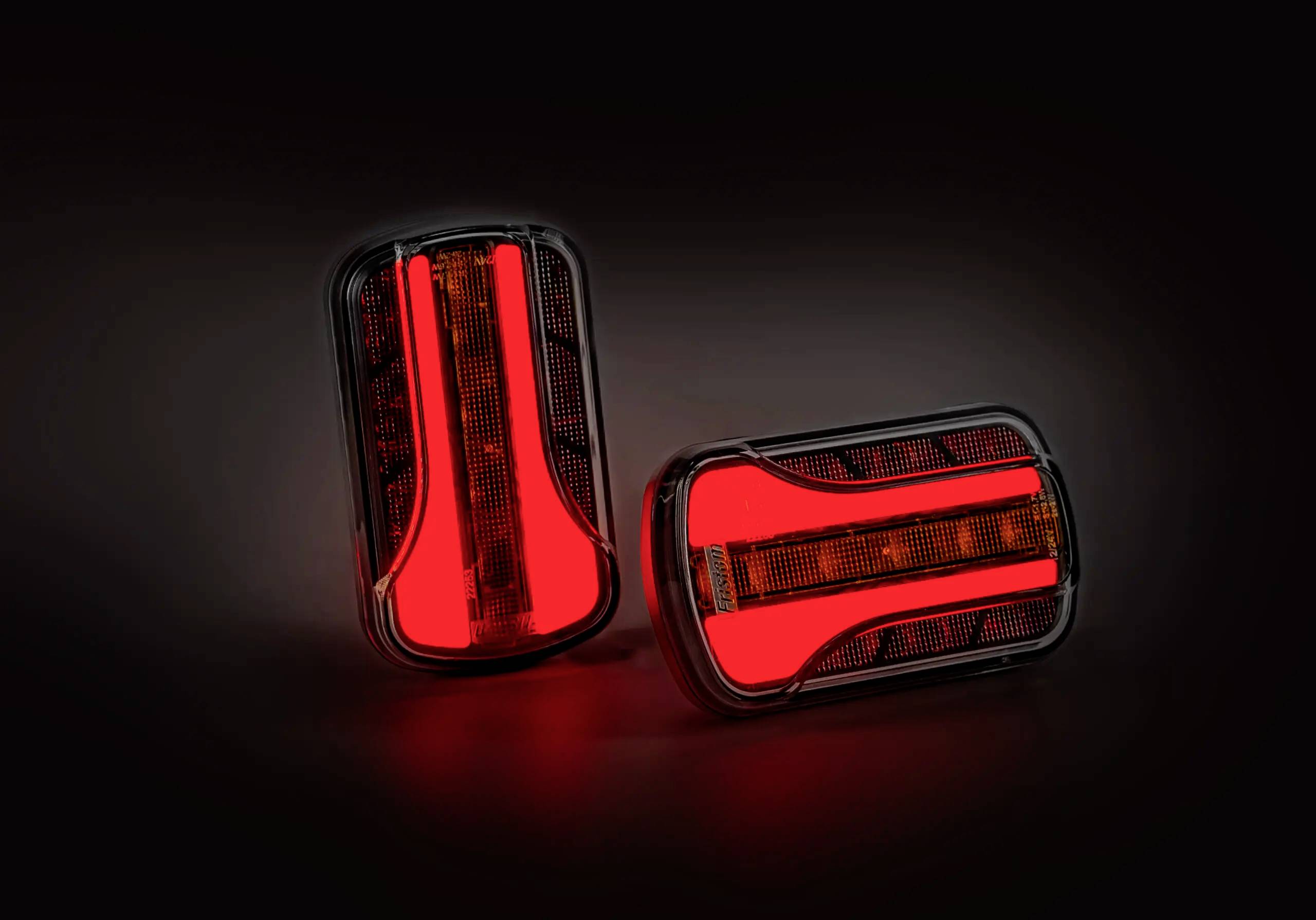 Dva svítící červené LED zadní světlomety na tmavém pozadí, které vykazují moderní a stylový design.