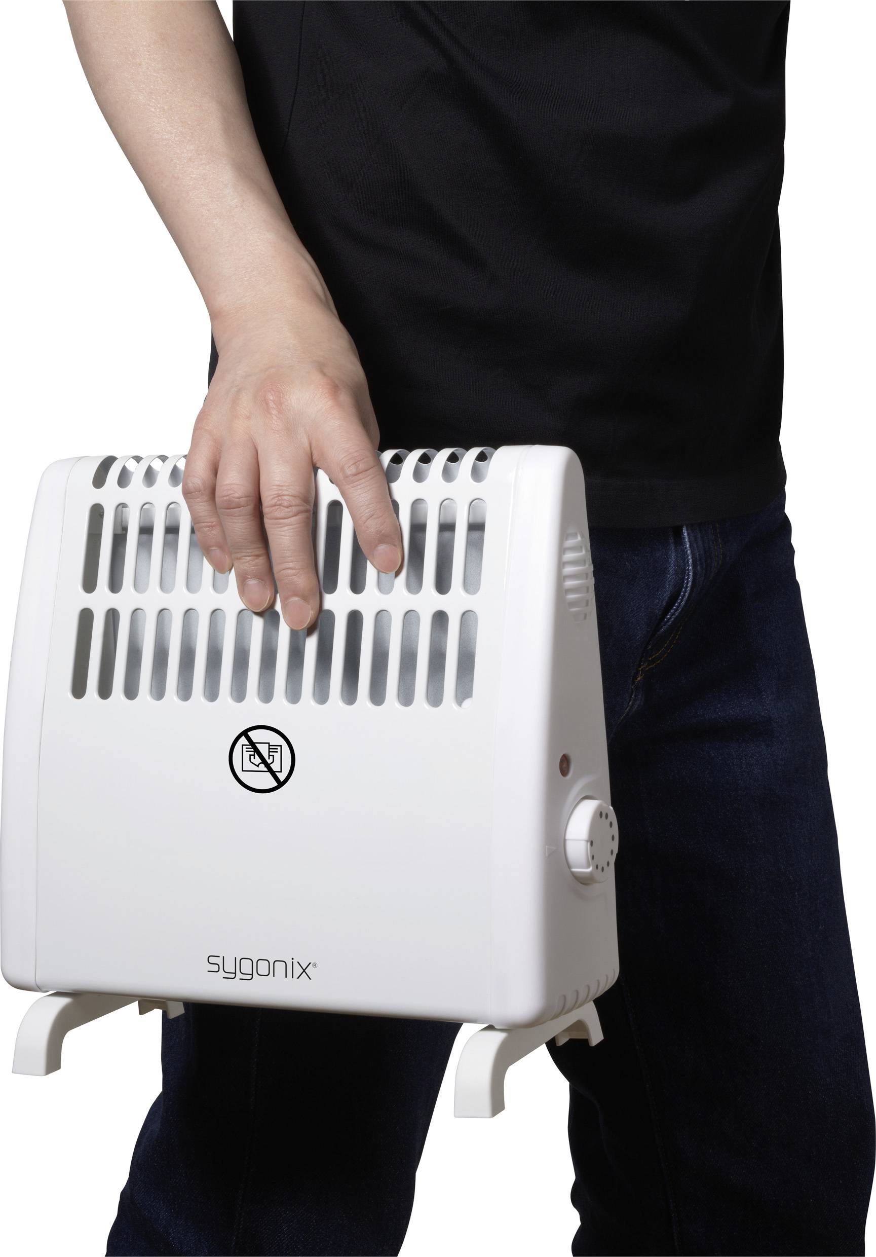 Člověk nese bílý teplovzdušný ventilátor značky sygonix. Zařízení má ventilační otvory, otočný spínač a symbol zákazu nošení.