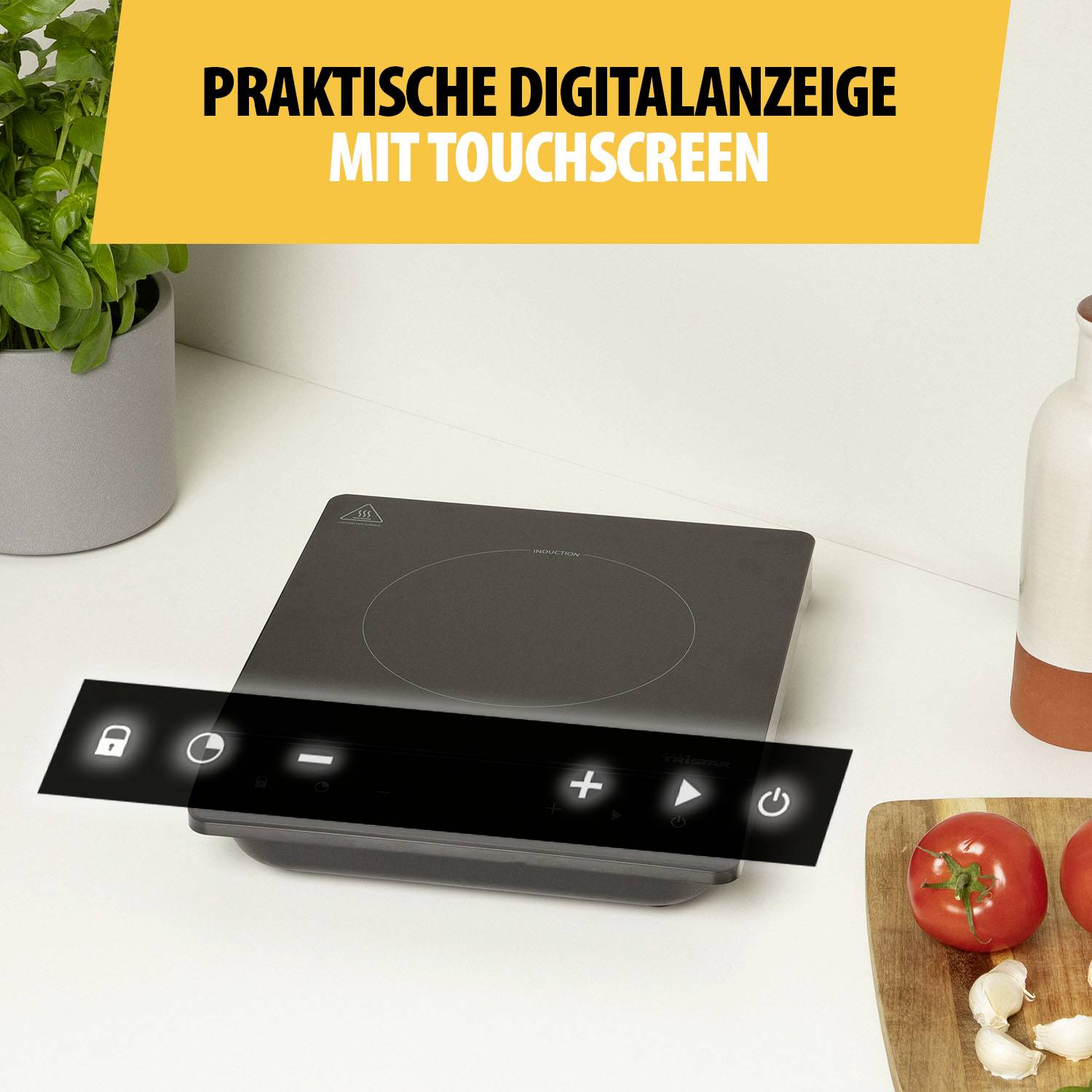 Praktický digitální displej s dotykovým ovládáním, černý skleněný povrch, červené rajčata a rostlina zdobí prostředí.