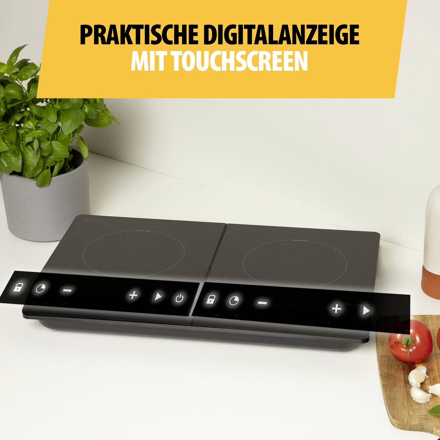 Varná deska s digitálním dotykovým displejem a ovládacími tlačítky, vlevo stojí rostlina, vpravo kuchyňská pomůcka.