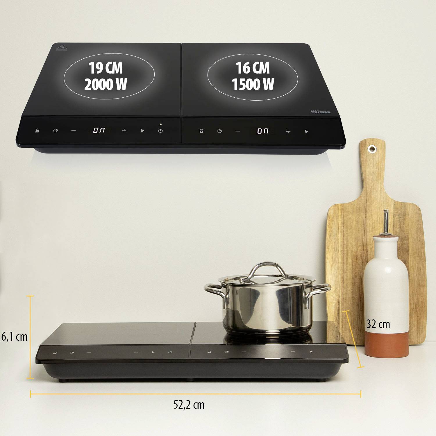 Dva černé indukční vařiče s displejem o výkonu 2000W a 1500W. Vedle nich hrnec, dřevěné prkénko a 32 cm vysoká láhev oleje.