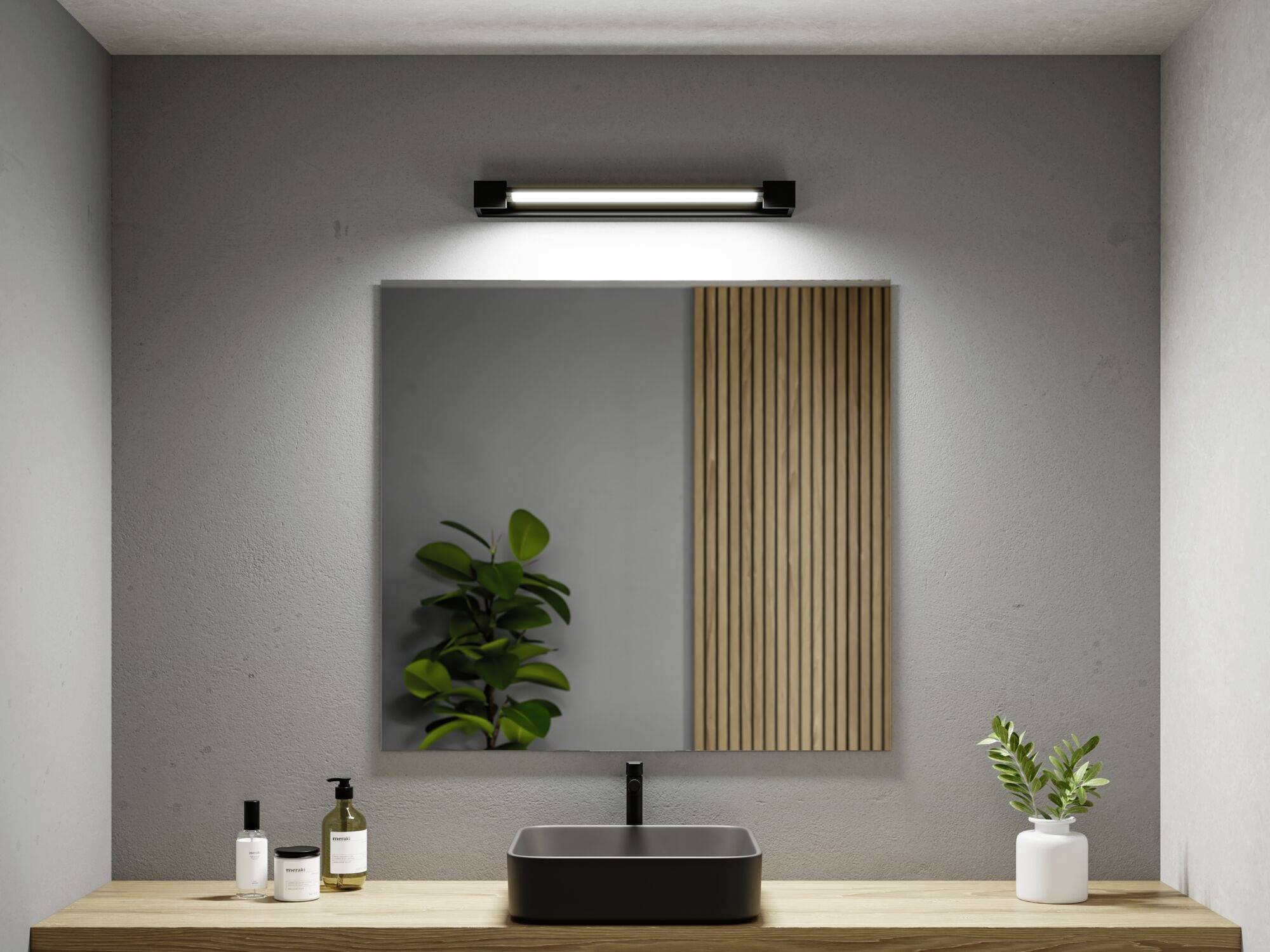 Moderní koupelna s obdélníkovým zrcadlem, černou baterií a umyvadlem. Vlevo rostlina v květináči, vpravo nástěnný panel.