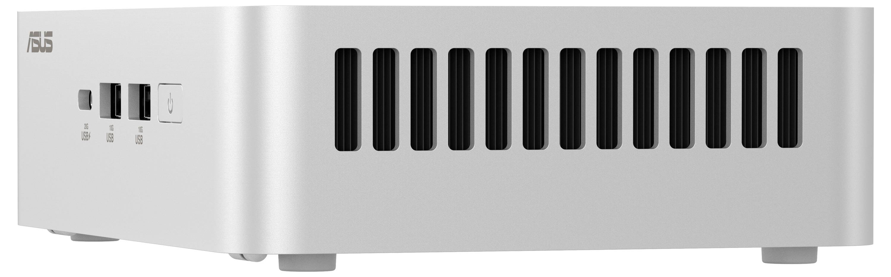 Stříbrný mini počítač od ASUSu s větracími otvory po stranách. Na přední straně jsou viditelné USB porty a symbol síťového vypínače.