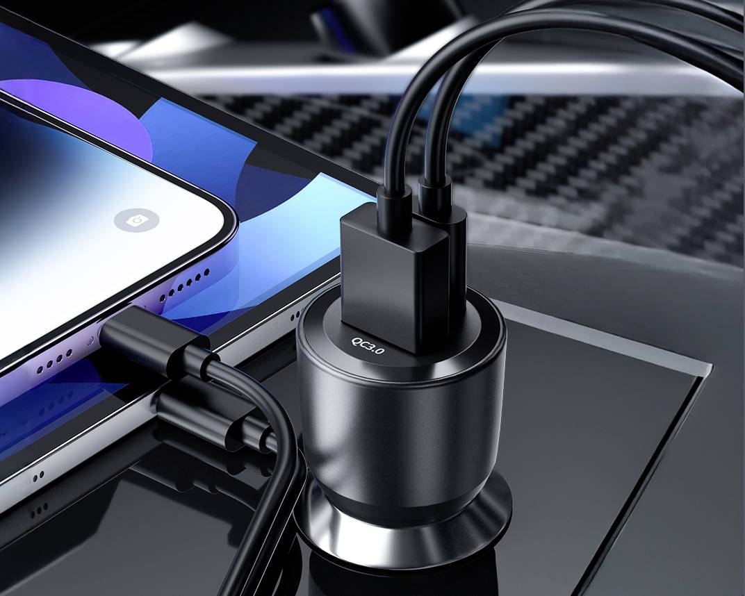 Nabíječka se třemi připojenými kabely nabíjí smartphone a další zařízení na lesklém povrchu.