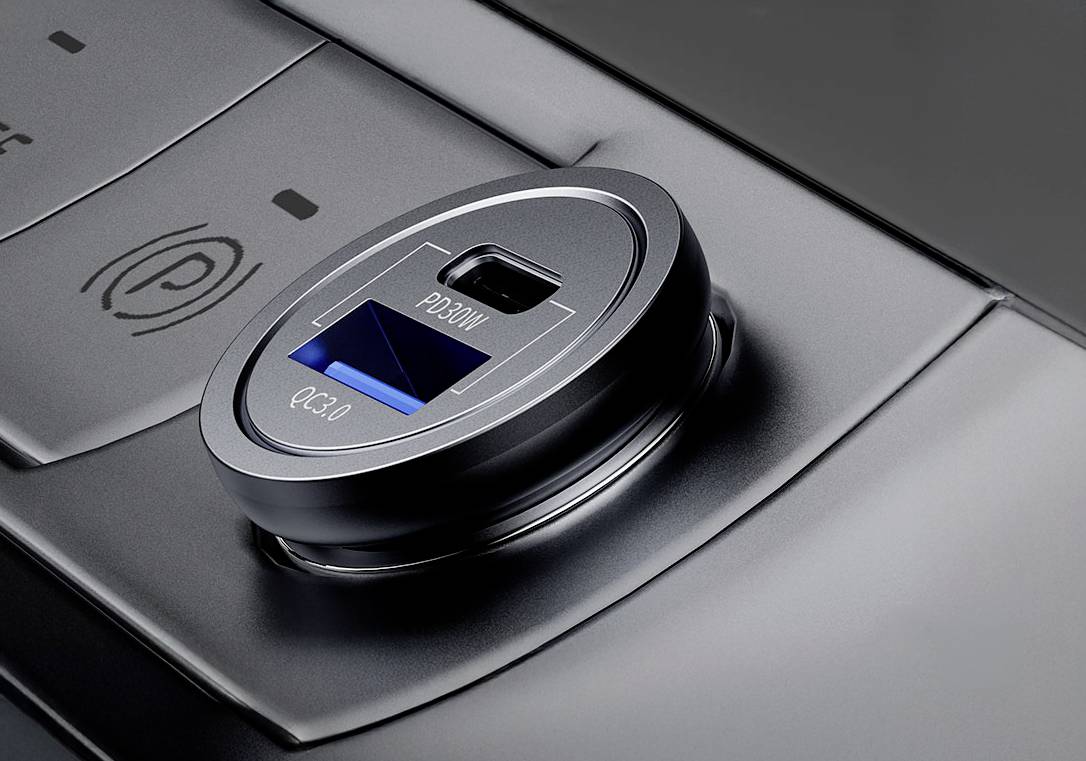 Černá USB nabíječka s modrou QC 3.0 a šedým tlačítkem PD20W je zabudována do konzole.