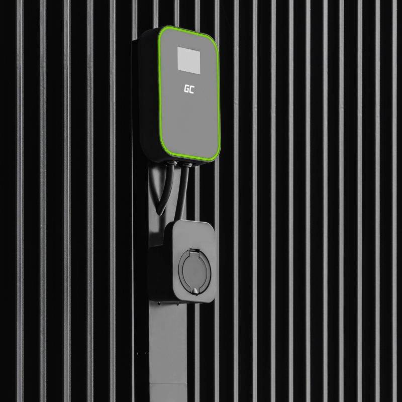 Nabíjecí stanice pro elektromobily namontovaná na černé stěně, s obrazovkou orámovanou zeleně a držákem kabelu.