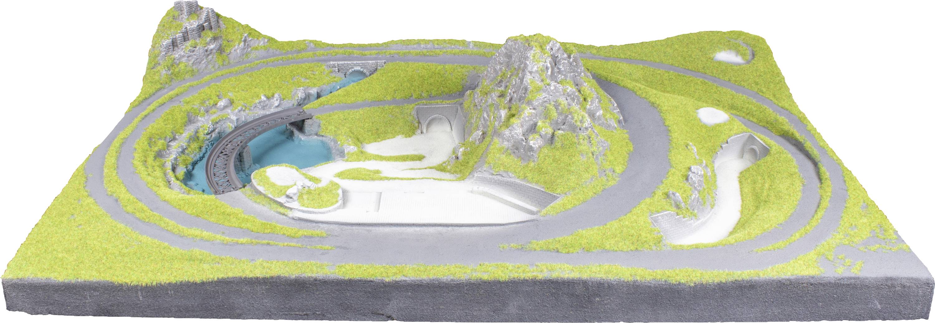 Miniaturní model zobrazuje krajinu s klikatými silnicemi, trávnatými kopci a malými vodními plochami. Ideální pro plánování modelové železnice.