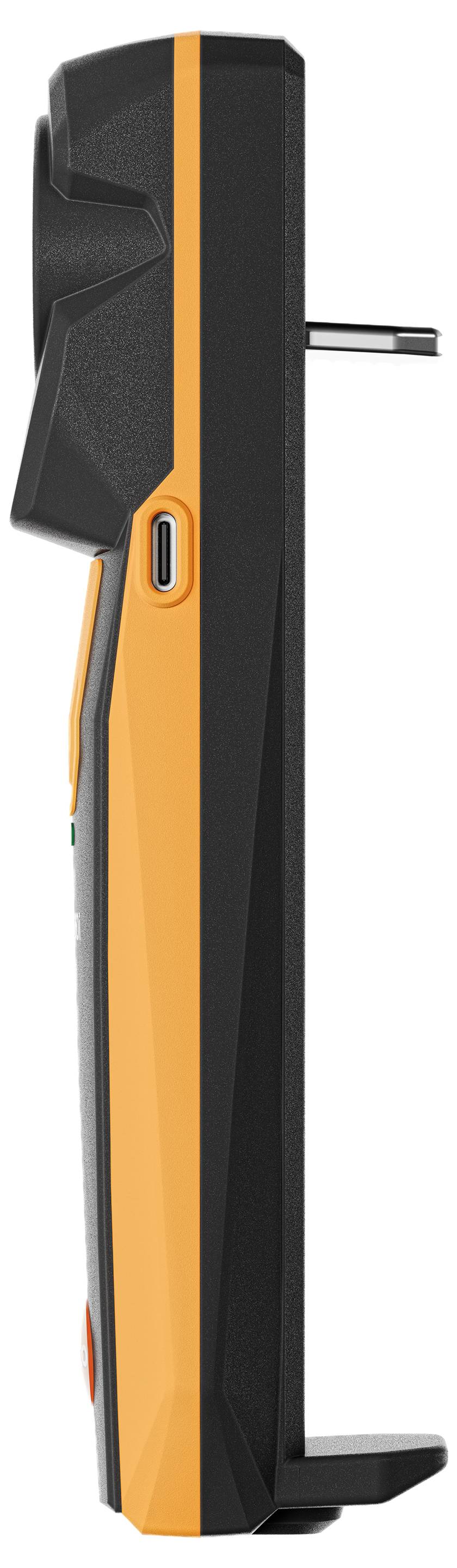 Černé a oranžové přenosné zařízení z pohledu z boku s viditelnými konektory, pravděpodobně elektronický měřicí přístroj.