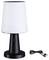 Černá stolní lampa s bílým stínidlem stojí vedle USB kabelu.