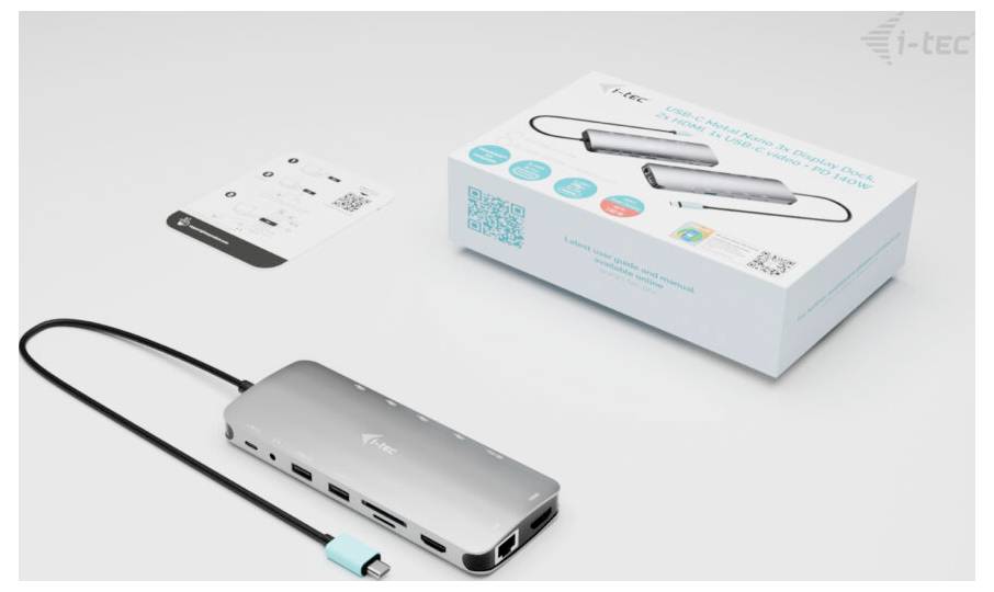USB-C dokovací stanice s několika porty a USB kabelem leží před svým obalem a návodem k použití.