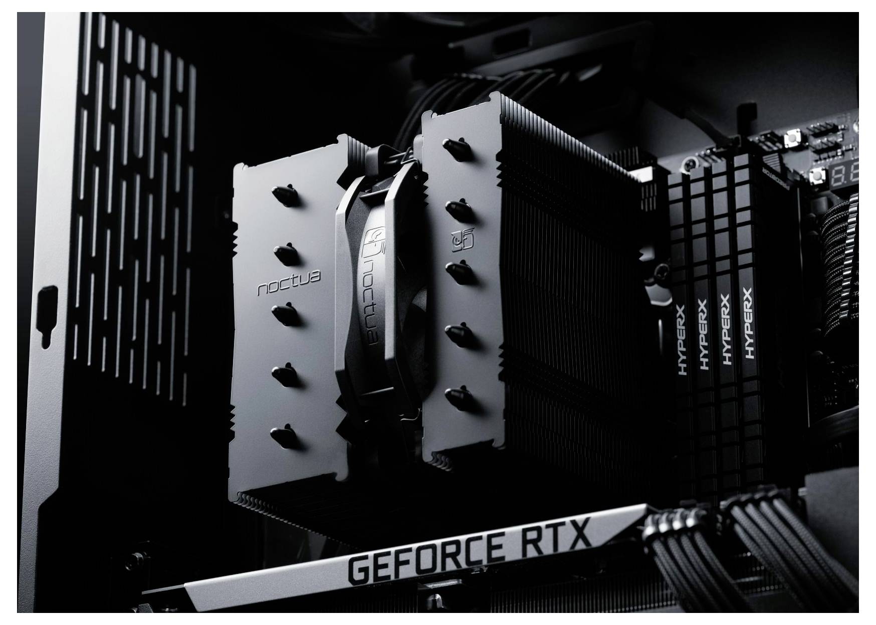 Detailní pohled do vnitřního prostoru počítače s velkým chladičem Noctua a grafickou kartou GEFORCE RTX, obklopenou paměťovými moduly HyperX.