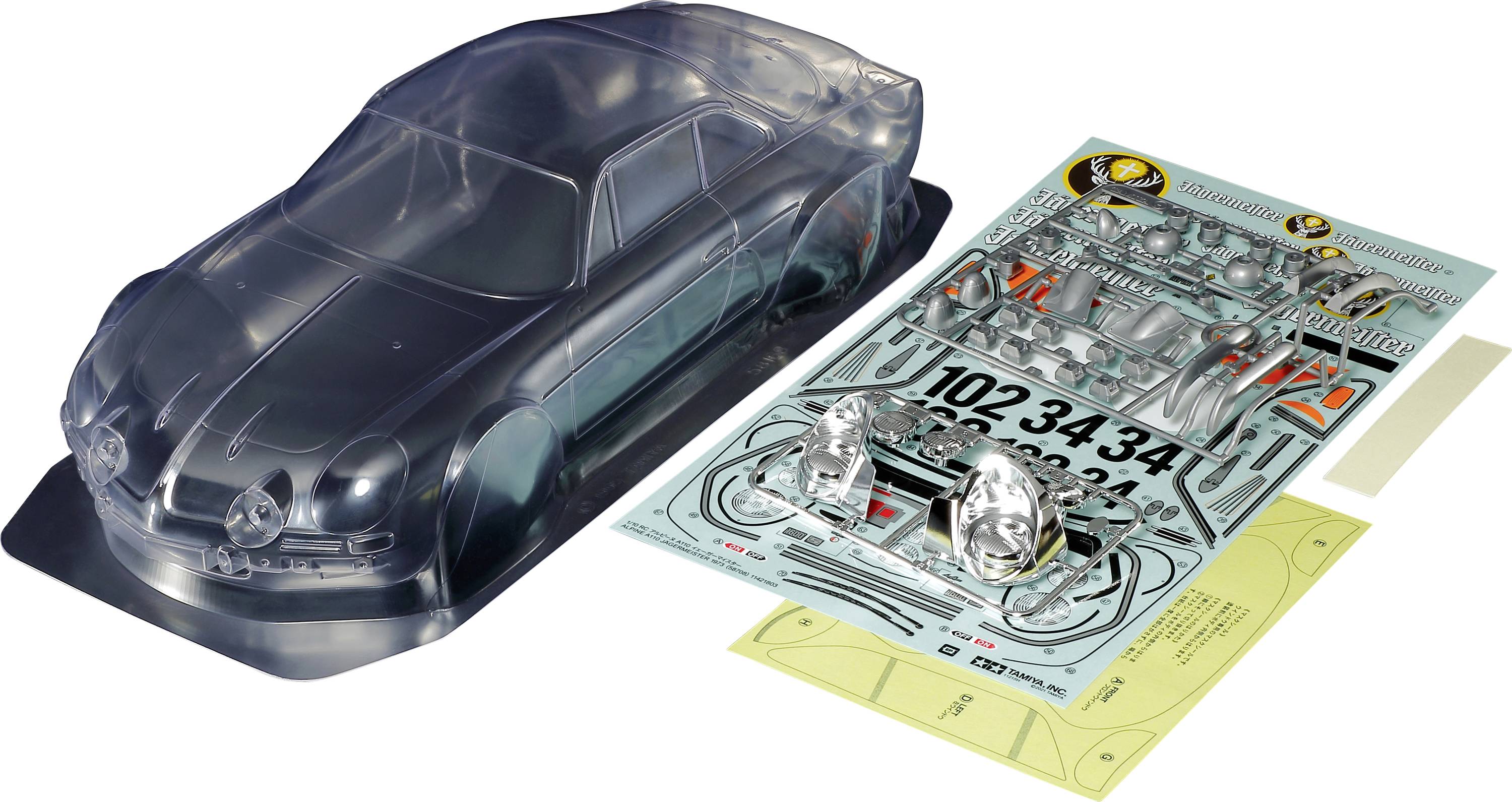 Plastový modelářský stavebnice automobilu s průhledným krytem, samolepkami a díly na stole.