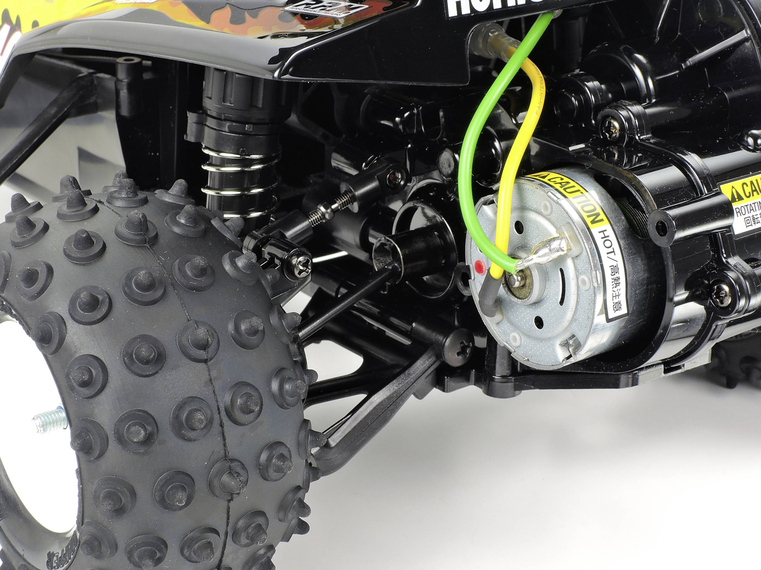 Detailní záběr motoru dálkově ovládaného vozidla s detaily kabelových připojení a odpružení.