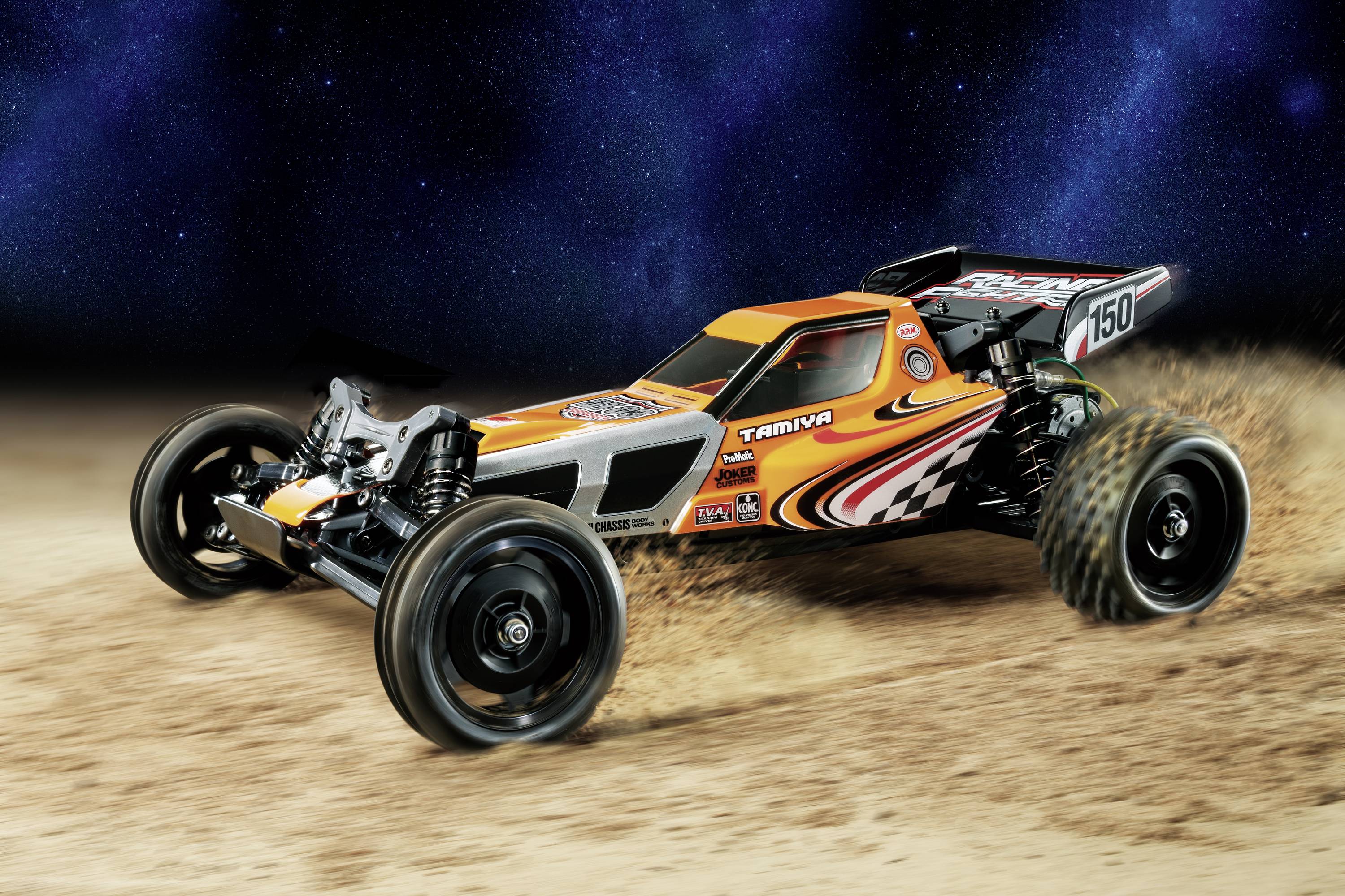 Dálkově ovládané auto v zářivých barvách rychle projíždí písčitým terénem před tmavou, hvězdnatou noční oblohou.
