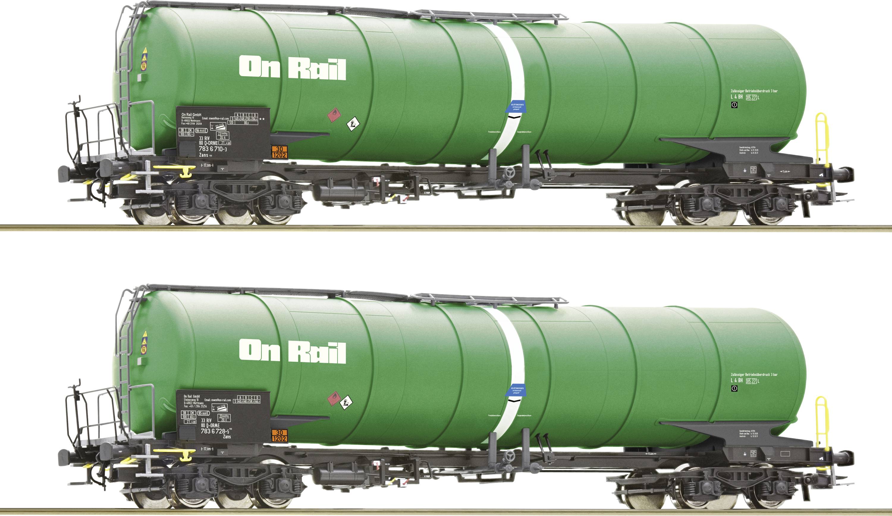 Dva zelené nákladní vozy s nápisem 'On Rail', stojící vedle sebe na kolejích.