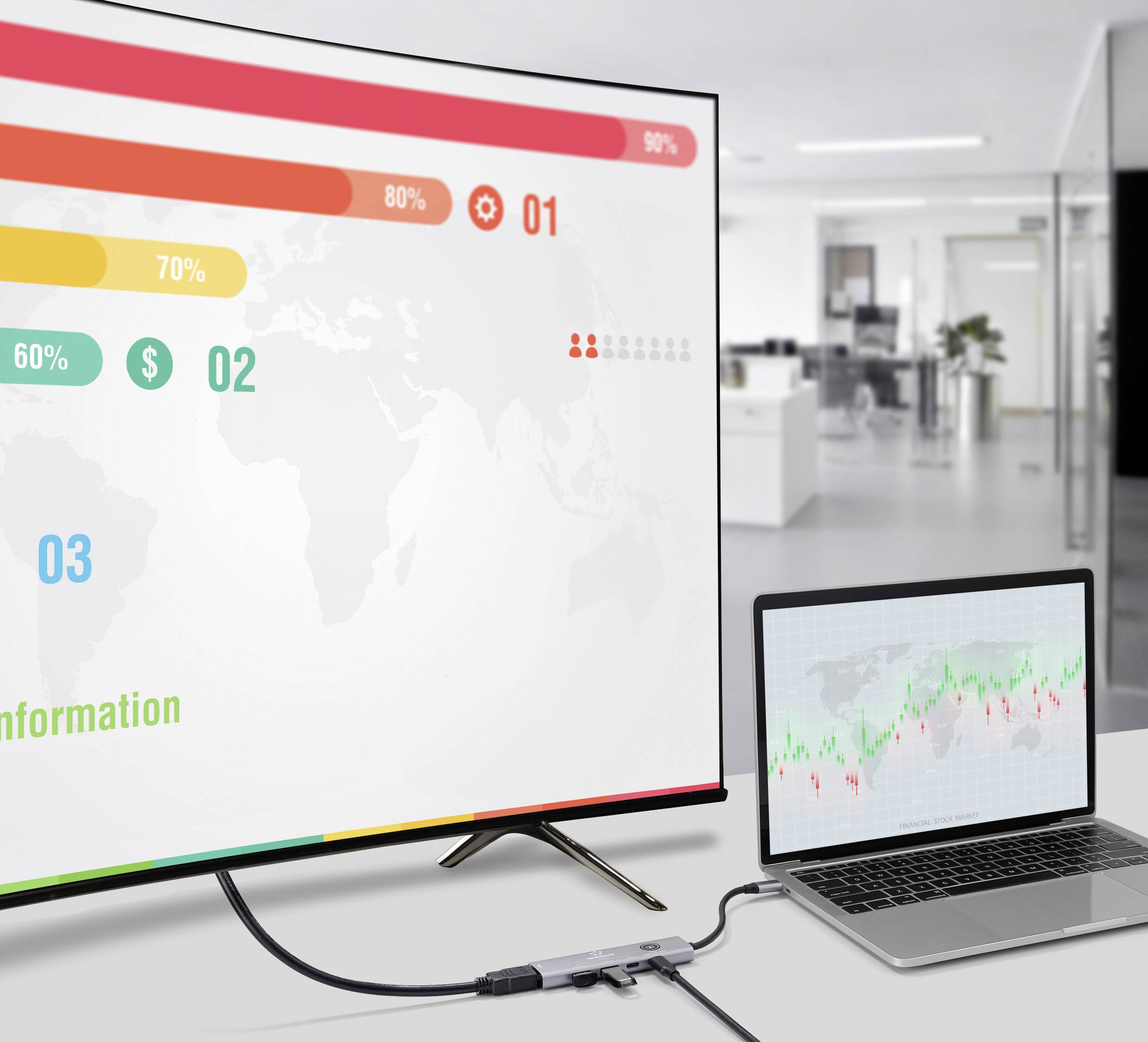 Velká obrazovka zobrazuje barevná data a statistiky překrývající mapu světa, zatímco laptop ukazuje čárový graf. Prostředí je kancelář.