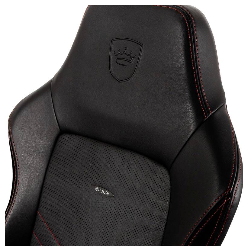 Černá herní židle s červenými švy a vyšitým logem na opěradle hlavy. Vysoce kvalitní materiál a ergonomický design.