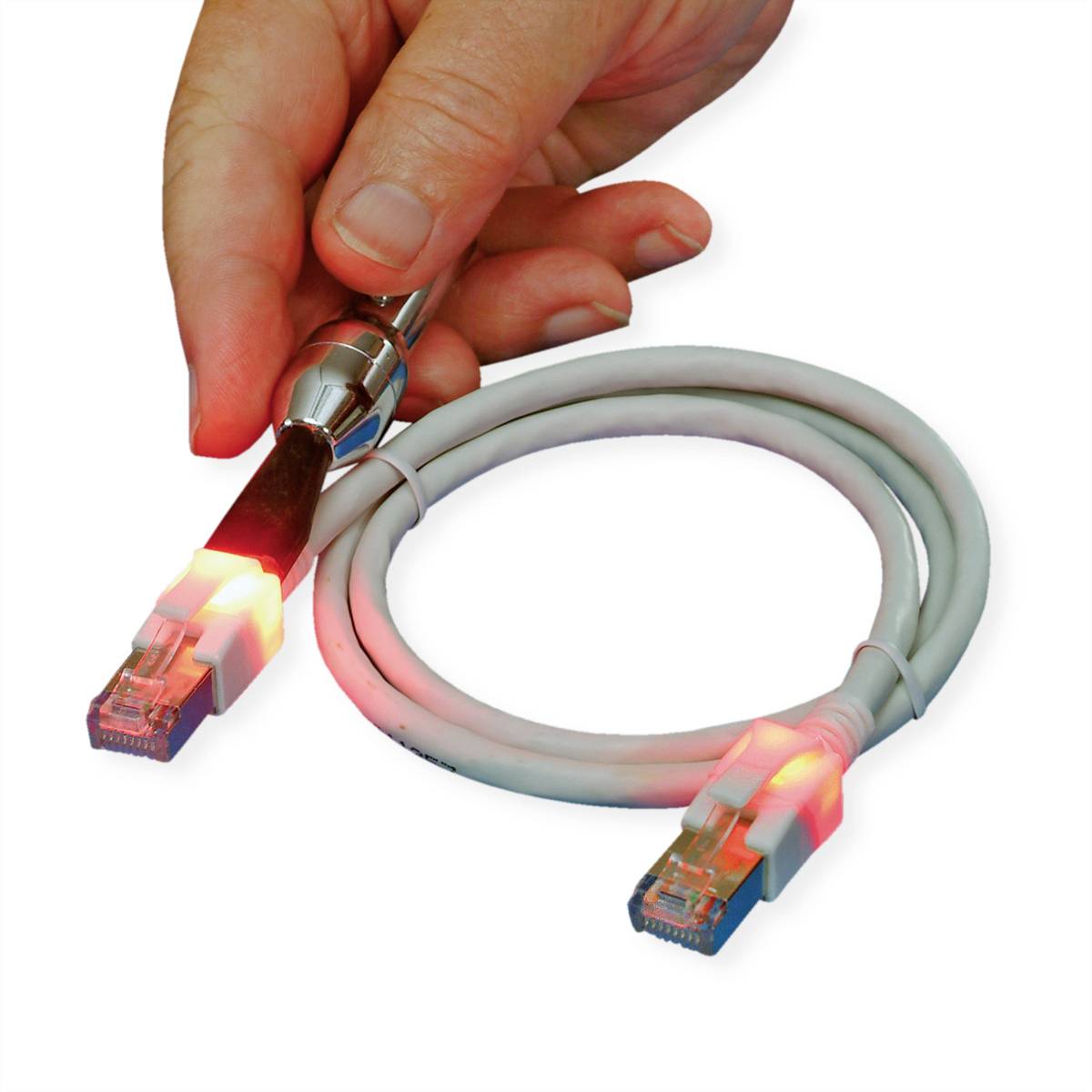 Ruka připojuje kovové zařízení pomocí ethernetového kabelu. Kabel svítí na koncích červeně.