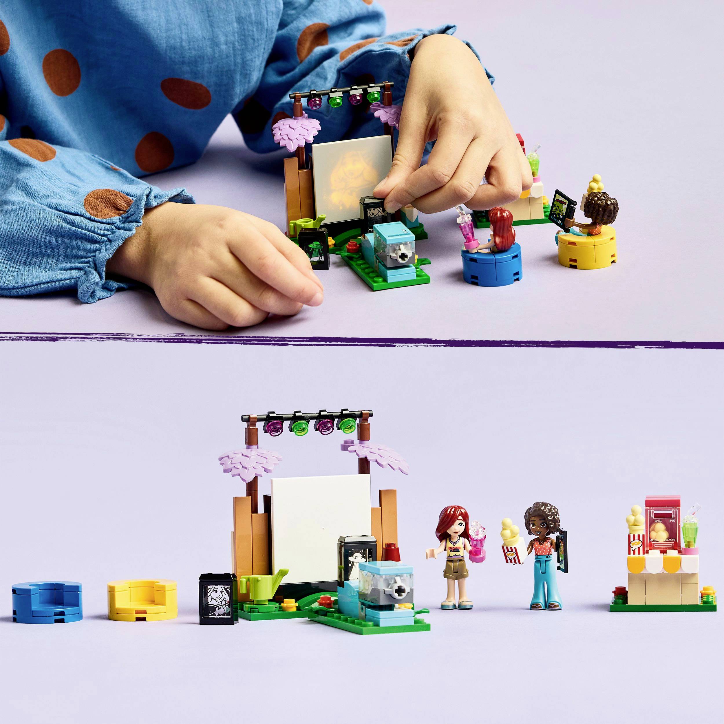 Dítě si hraje s LEGO figurkami a filmovým setem. Postavené jsou malé figurky a obrazovka.