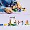 Dítě si hraje s LEGO figurkami a filmovým setem. Postavené jsou malé figurky a obrazovka.