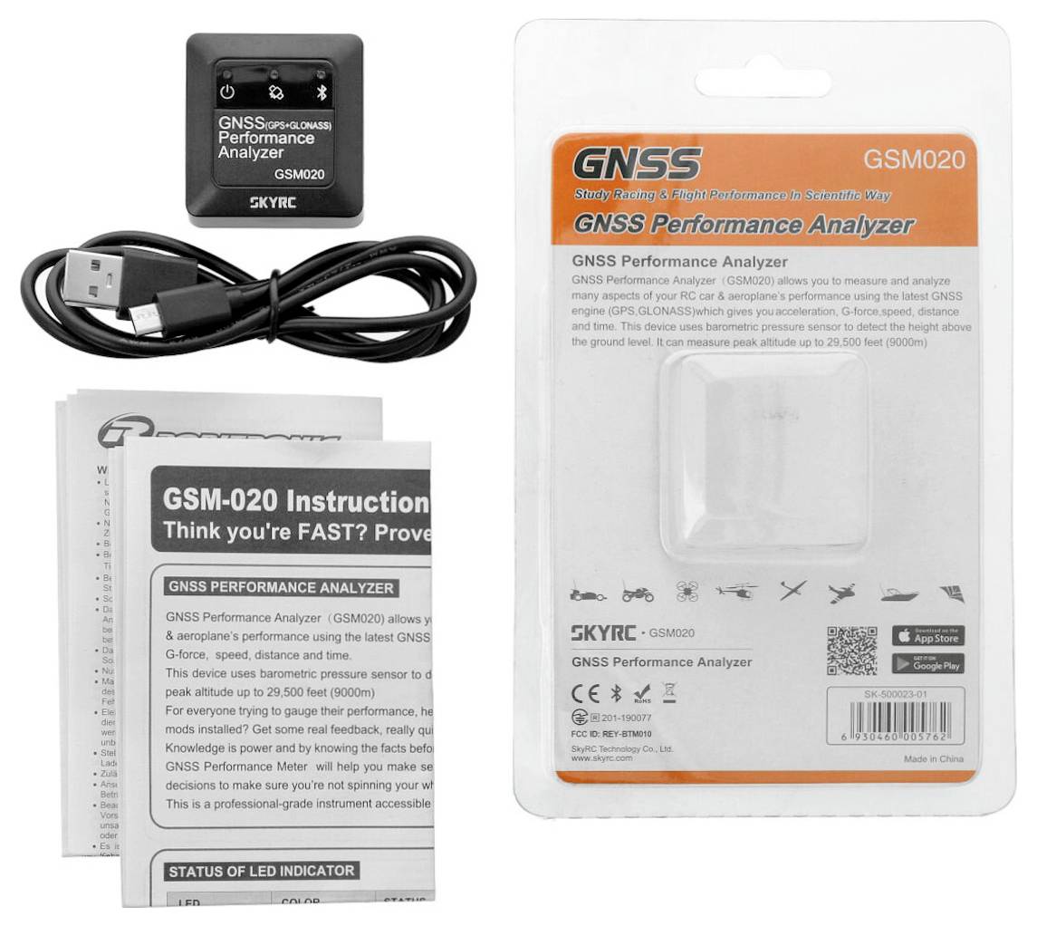 Analyzátor výkonu GNSS a příslušenství, včetně USB nabíjecího kabelu a návodů, na bílém pozadí.